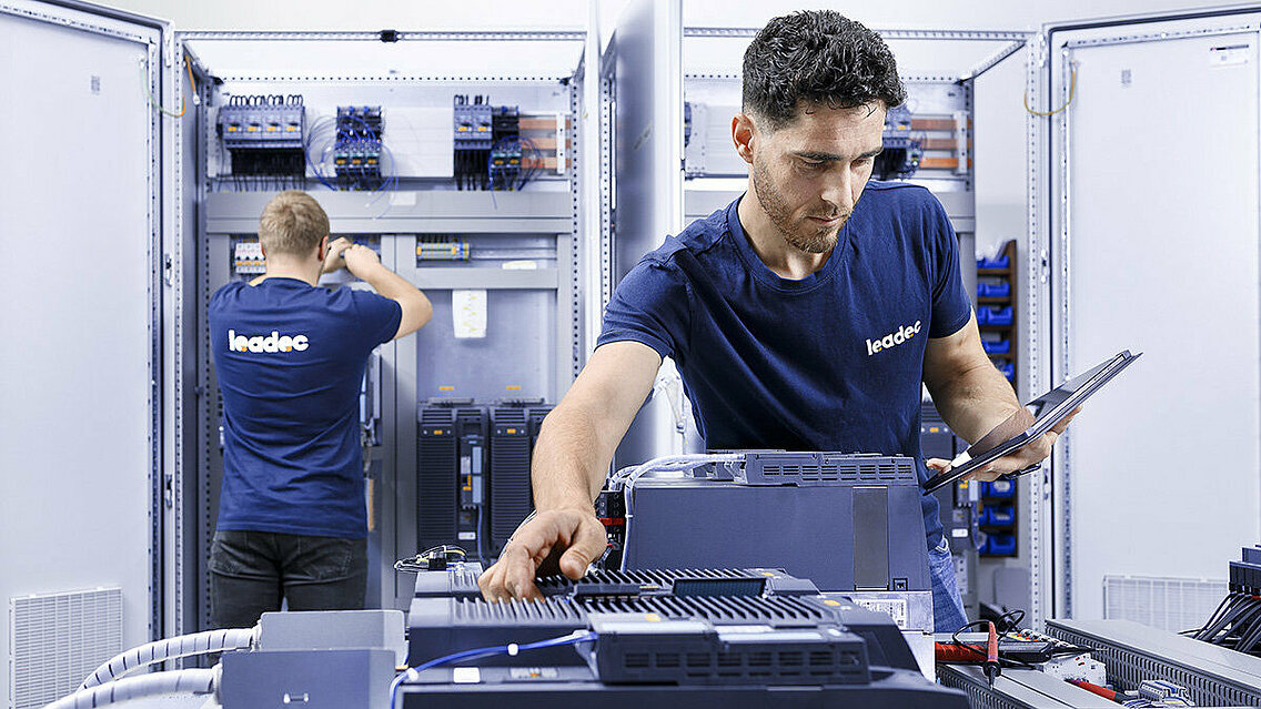 Two Leadec employees checking switch cabinets.