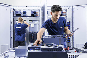 Two Leadec employees checking switch cabinets.