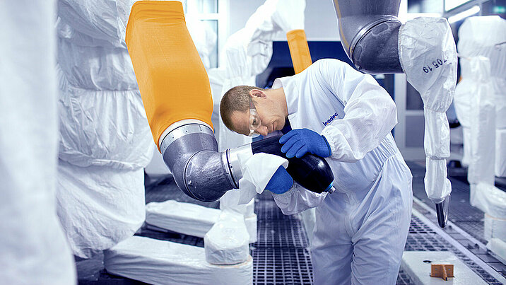 Leadec employee cleaning robot in a paint shop. 